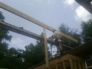 Carpenter setting a ridge beam over a new addition frame — Ice Dam Removal by Roofing Brothers in Alcester