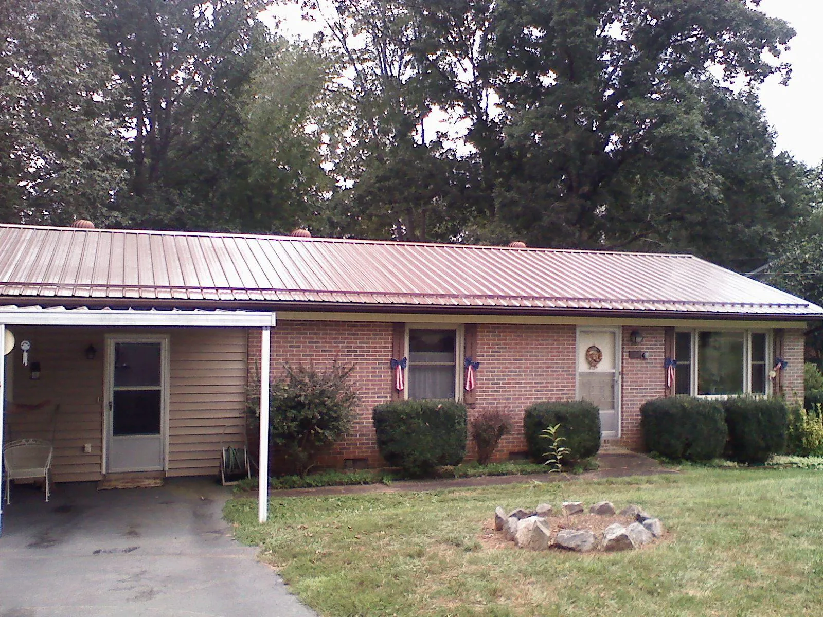 Bronze metal roof and carport on a brick ranch home — Roof Repair work by our crew in Alcester
